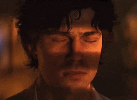 a close up of a man 's face with his eyes closed in a dark room