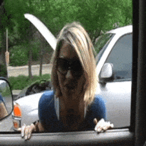a woman wearing sunglasses looks out the window of a car
