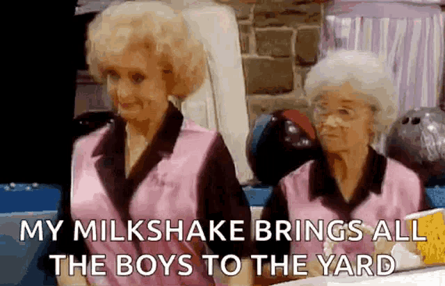two older women are standing next to each other in a bowling alley and talking about their milkshake .