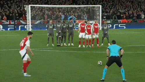 a soccer player wearing a red jersey with the number 21 on it kicks the ball