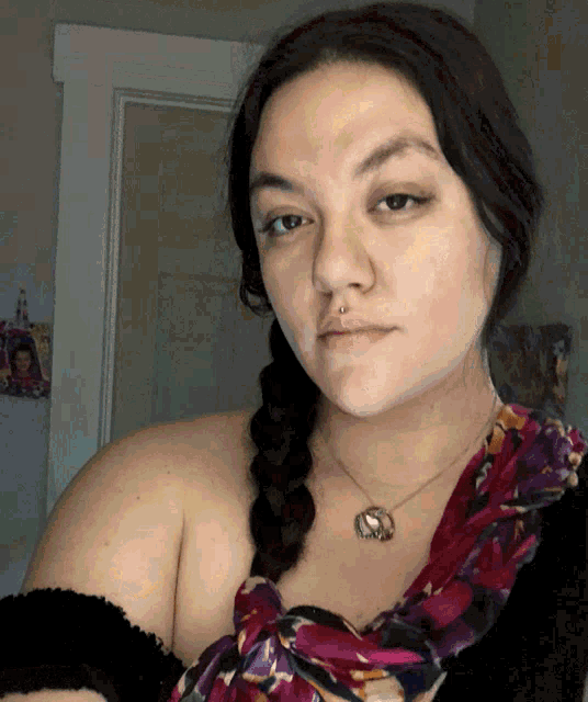 a woman wearing a braided ponytail and a necklace