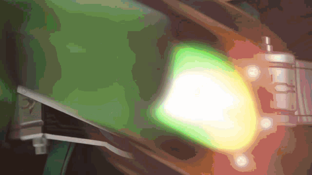 a green and yellow light is shining on a metal object