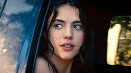 a close up of a woman looking out of a car window .