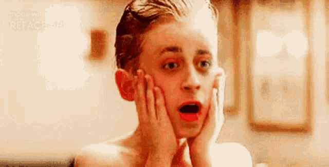 a shirtless boy with red lipstick on his face is making a funny face .
