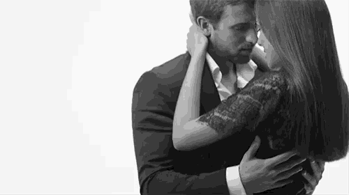 a black and white photo of a man and a woman hugging