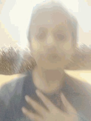 a blurry picture of a person 's face with their hand on it