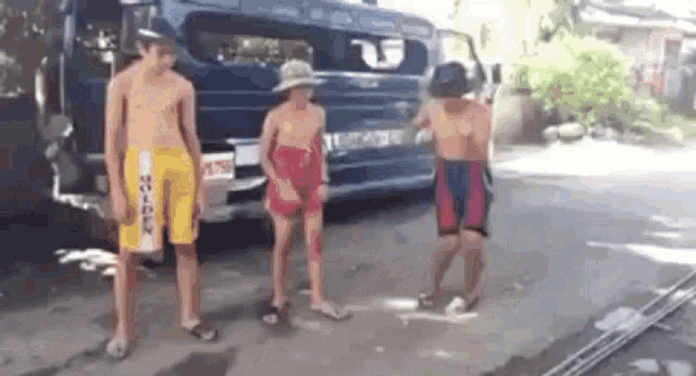 a group of young men are standing next to each other on a street .