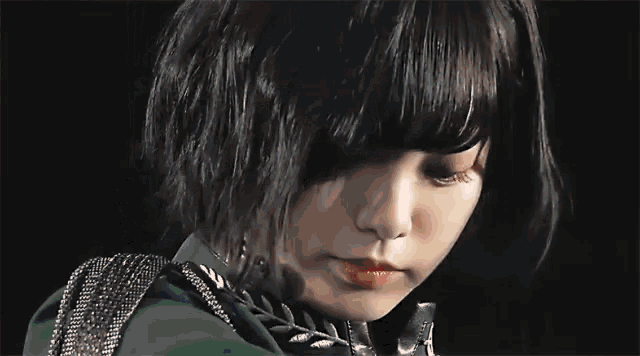 a close up of a woman 's face with a green jacket on