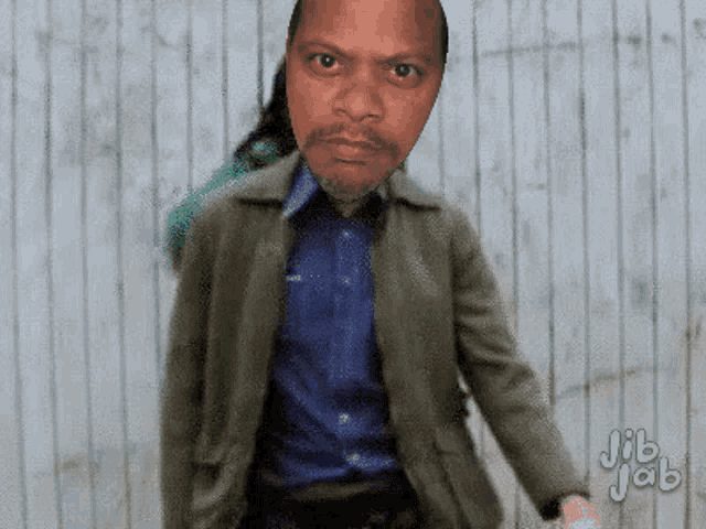 a man in a green jacket is standing in front of a wooden wall with jib jab written in the corner