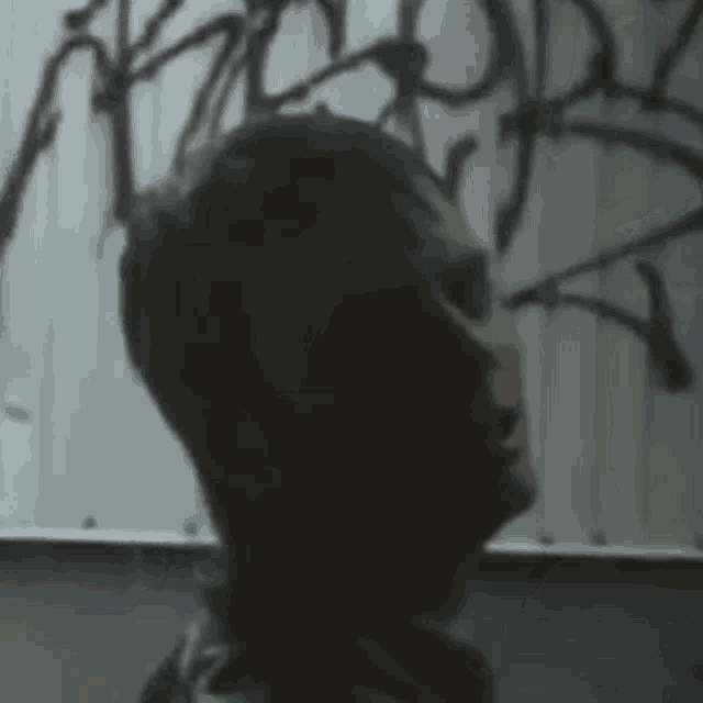 a close up of a man 's face in front of a wall with graffiti on it .