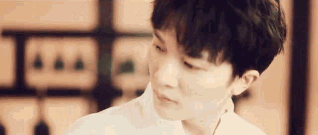 a close up of a person 's face with a white shirt