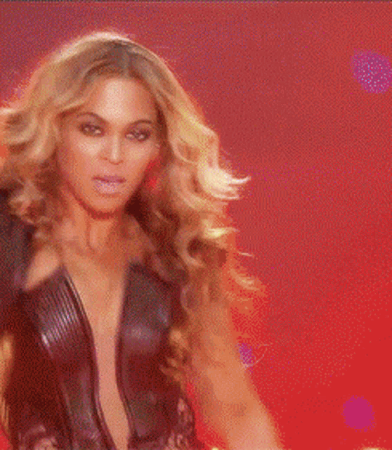 a woman with long blonde hair is dancing on a red background