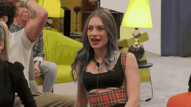 a woman with blue hair is sitting on the floor in front of a lamp .