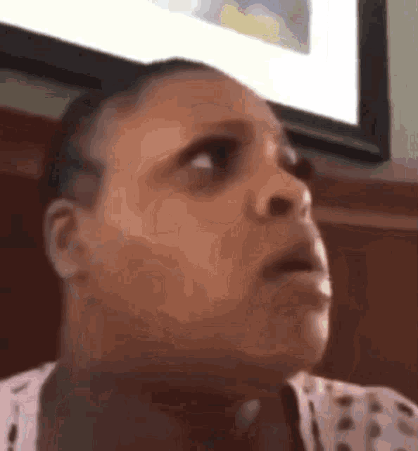 a woman is making a funny face in front of a tv .