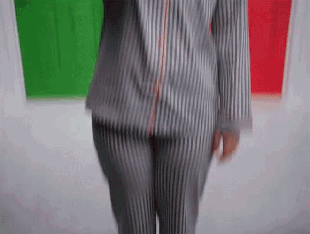 a woman in a striped shirt and striped pants is walking