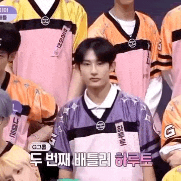 a group of young men are standing next to each other wearing pink and yellow jerseys .