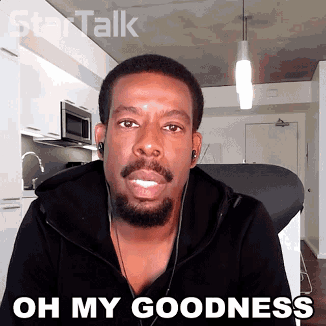 a man with a beard and ear buds says oh my goodness