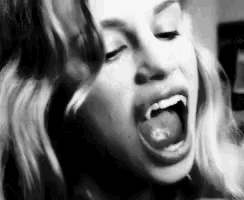 a black and white photo of a woman with her mouth open and her tongue out .