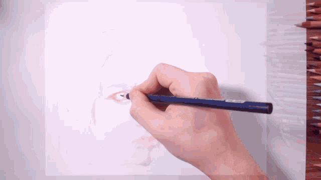 a person is drawing a face with a pencil