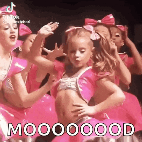 a group of young girls are dancing together in pink outfits and bows .