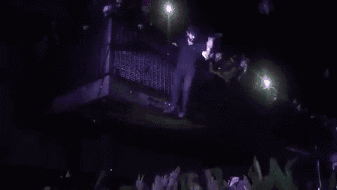 a person is taking a picture of a crowd of people at a concert with their phone .