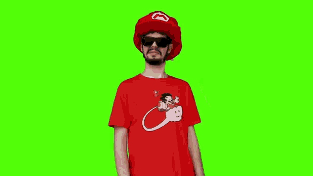 a man wearing a red hat , sunglasses and a red shirt is dancing on a green screen .