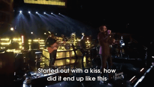 a man singing into a microphone with the words " started out with a kiss how did it end up like this " below him