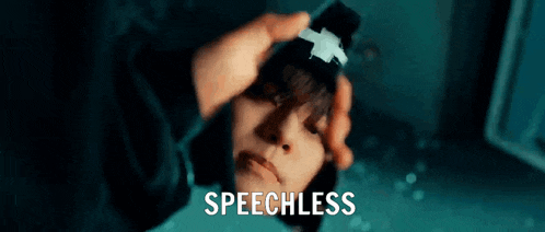 a person is holding a cell phone in front of a mirror and the word speechless is visible