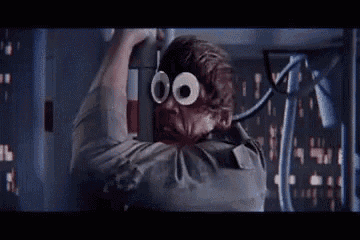 a man wearing googly eyes is hanging from a wall .
