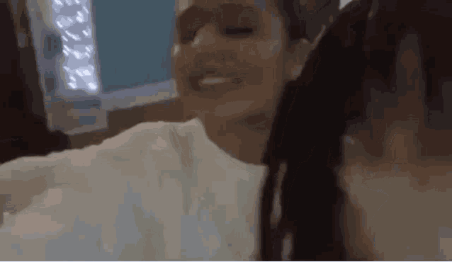 a woman is taking a selfie with another woman in a bedroom .