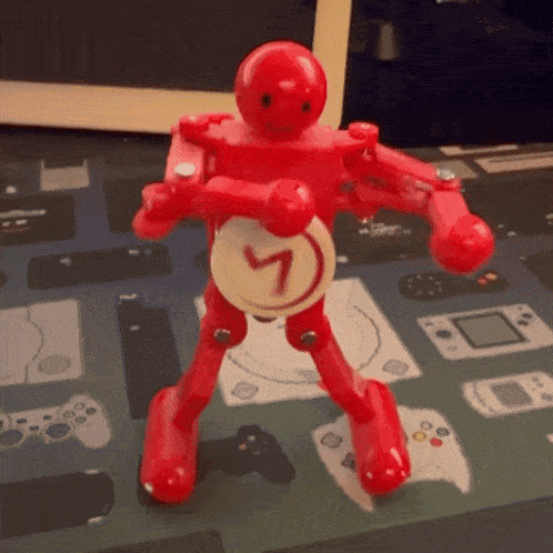 a red toy robot with a clock on his back that says 7