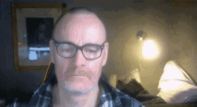 a man wearing glasses is looking at the camera