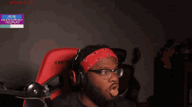 a man wearing headphones and a red bandana sitting in a vertage chair