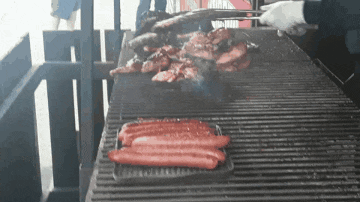 hot dogs are being cooked on a grill with meat