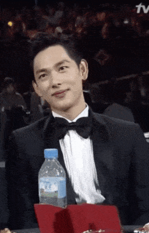 a man in a tuxedo with a bottle of water