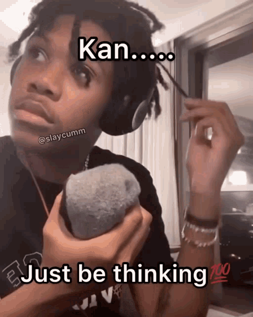 a man wearing headphones holds a sock in his hand and says " kan just be thinking "