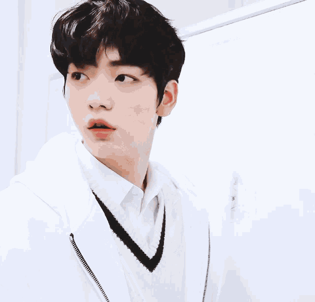 a close up of a person wearing a white shirt and sweater