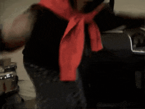 a person with a red scarf around their neck standing in front of a microphone