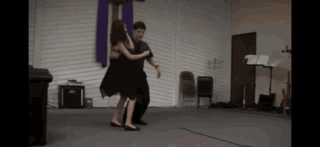 a man and a woman are dancing in a room with a peavey amplifier
