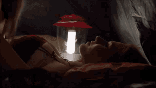 a close up of a woman laying on a bed with her eyes closed and her mouth open .