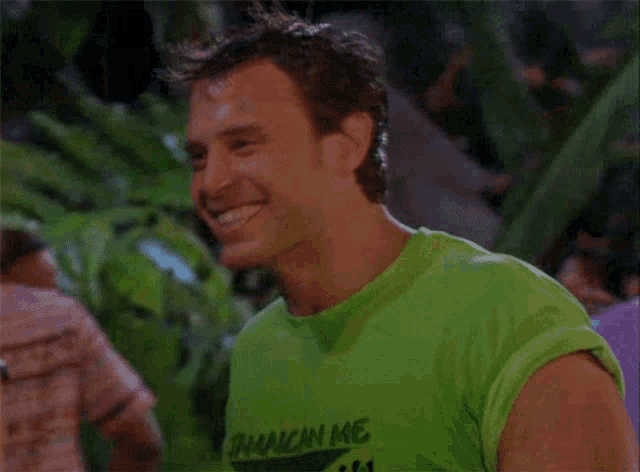 a man wearing a green shirt that says jamaican me is smiling