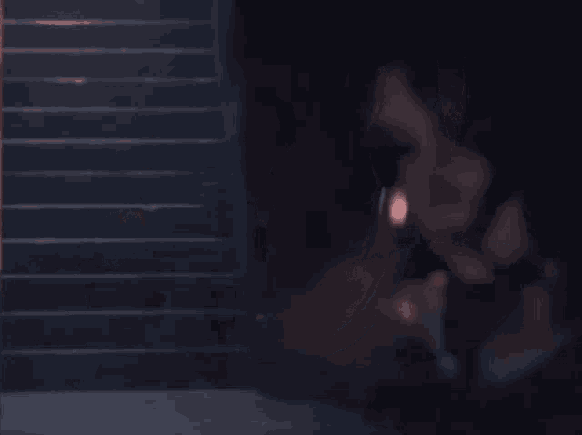 a woman in a dark room looks at the camera