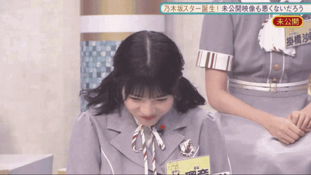 a girl in a suit has a name tag that says ' aoyama ' on it