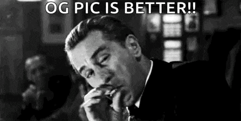 a man in a suit and tie is smoking a cigarette and making a funny face .