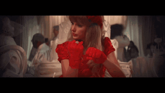a woman wearing a red dress and red gloves
