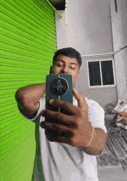 a man taking a selfie with a green shutter in the background
