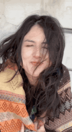 a woman with her eyes closed is wrapped in a blanket