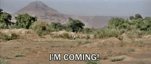 a man walking in a field with the words " i 'm coming "