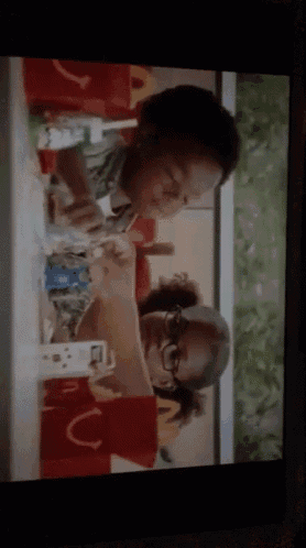 a couple of people sitting at a table with a mcdonald 's logo in the background
