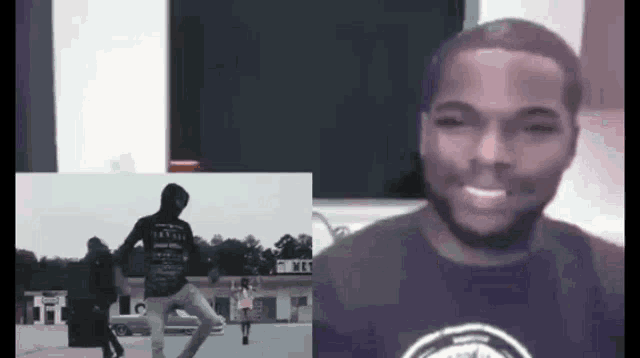 a man in a black shirt is smiling in front of a picture of a man on a skateboard .